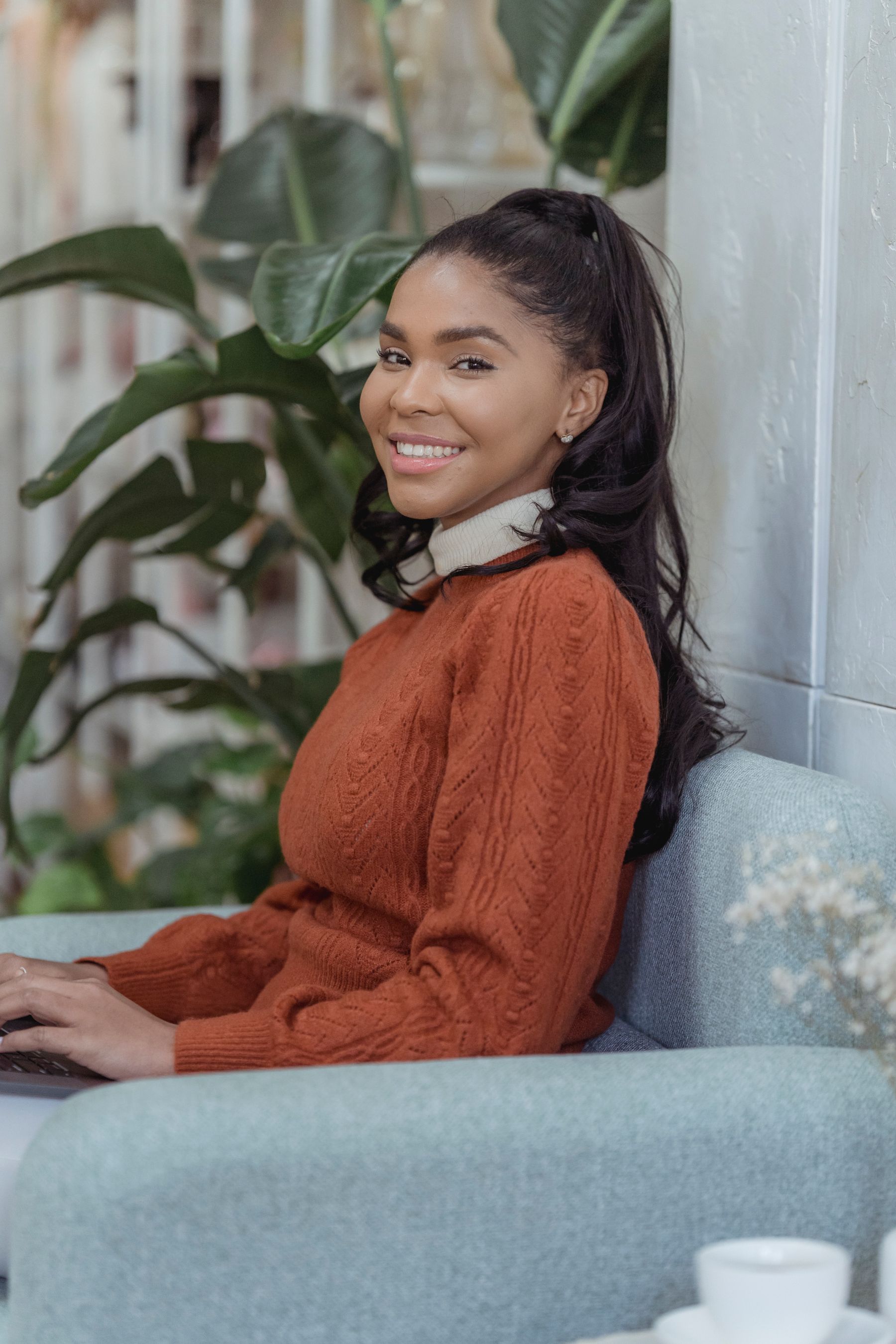 A smiling customer seated comfortably at home with a laptop